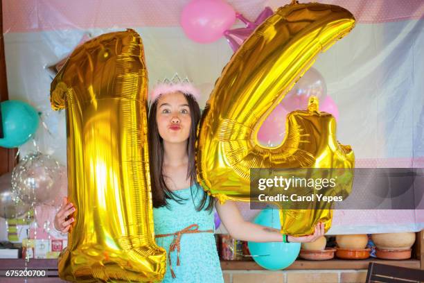 teenager holding 14 number balloons on her birthday - number 14 stockfoto's en -beelden