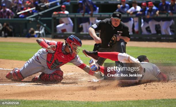 Carlos Gomez of the Texas Rangers is called out at the plate by umpire Bill Miller after being tagged by Martin Maldonado of the Los Angeles Angels...