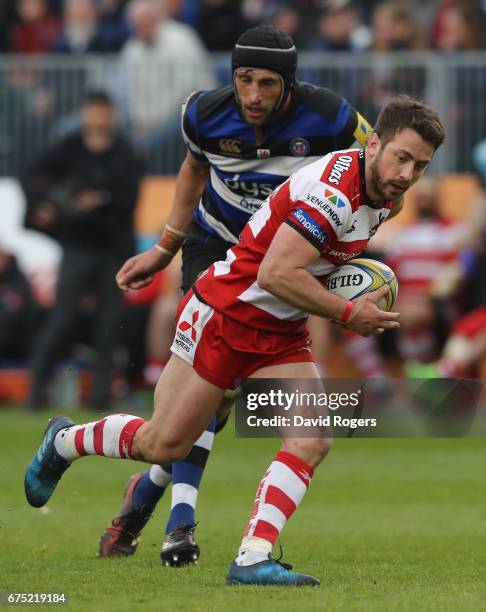 Greig Laidlaw of Gloucester runs with the ball past Luke Charteris during the Aviva Premiership match between Bath and Gloucester at the Recreation...