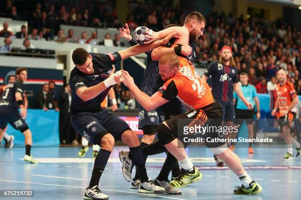 Matej Gaber of MOL Pick Szeged is trying to shoot the ball against Nedim Remili and Luka Karabatic of Paris Saint Germain during the Champions League...