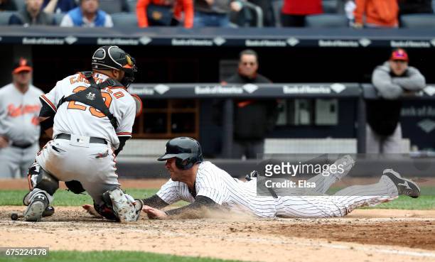 Austin Romine of the New York Yankees is out at home as catcher Welington Castillo of the Baltimore Orioles makes the out in the 10th inning on April...