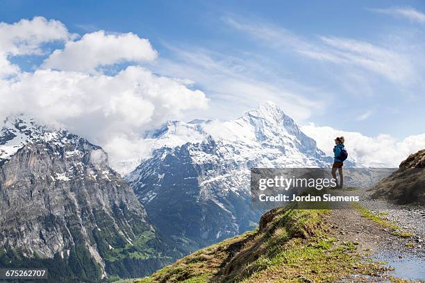 a woman hiking in the swiss alps - mountain peak path stock pictures, royalty-free photos & images