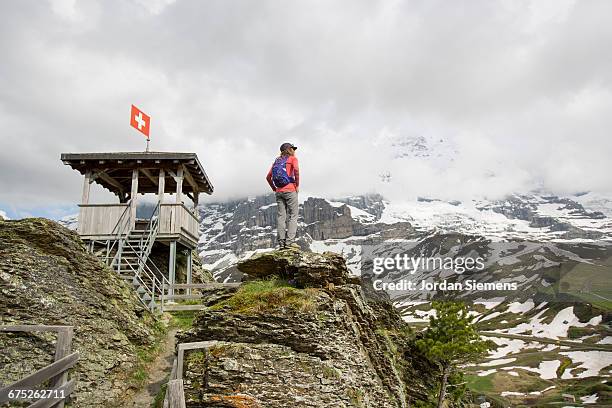a woman hiking in the swiss alps - schweizer flagge stock-fotos und bilder