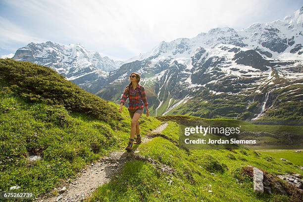 a woman hiking a trail in the alps - lauterbrunnen photos et images de collection