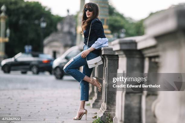 Sarah Benziane, fashion blogger, wears a Ted Baker top, Pimkie blue denim ripped jeans, Newlook gold heels shoes, a Furla white bag, and Asos...