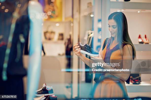 joven hermosa chica está buscando zapatos en el centro comercial - zapatos mujer fotografías e imágenes de stock