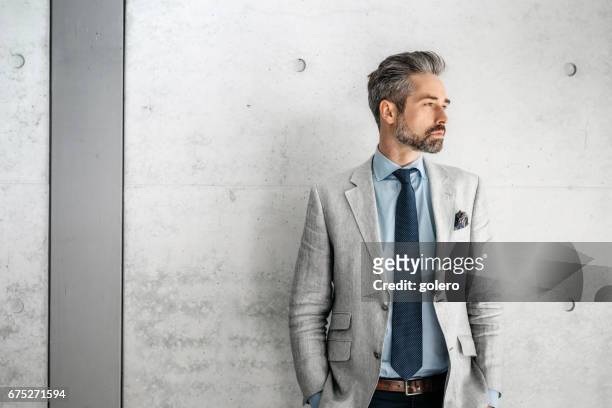 優雅英俊的鬍鬚商人站在與狗在商業區 - blazer jacket 個照片及圖片檔