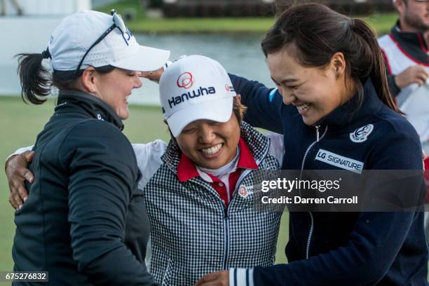 Haru Nomura of Japan is embraced by Caroline Masson of Germany and In Gee Chun of South Korea following her victory at the Volunteers of America...