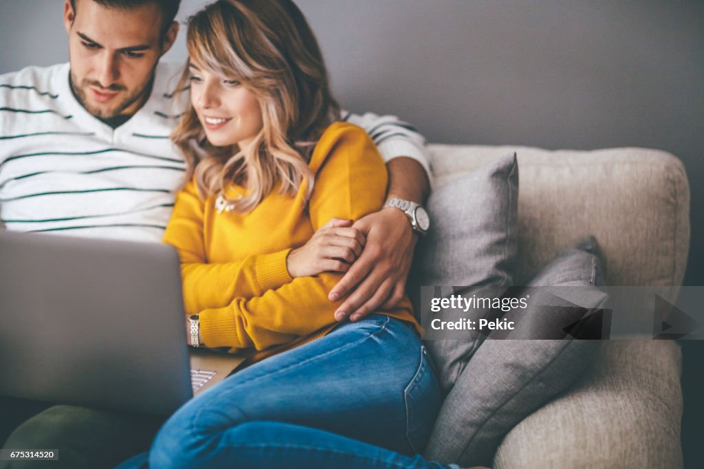 Smiling couple looking at laptop