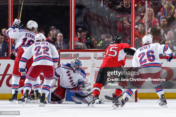 Henrik Lundqvist of the New York Rangers makes a glove save against Zack Smith of the Ottawa Senators as Marc Staal, Nick Holden and Jimmy Vesey of...
