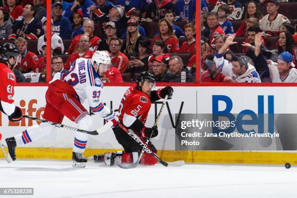 Cody Ceci of the Ottawa Senators clears the puck from his knees as Mika Zibanejad of the New York Rangers skates for the puck in Game Two of the...