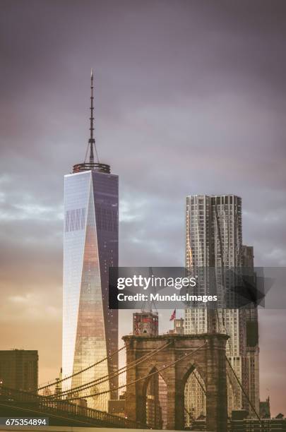 brooklyn bridge and freedom tower of the world trade center in new york city - freedom tower stock pictures, royalty-free photos & images