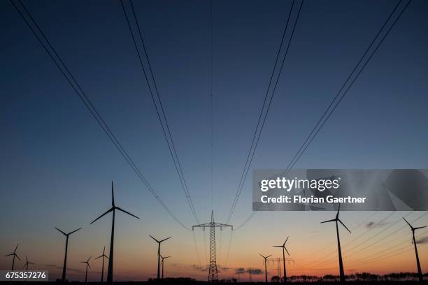 Power poles and wind turbines are captured on April 30, 2017 in Nauen, Germany.