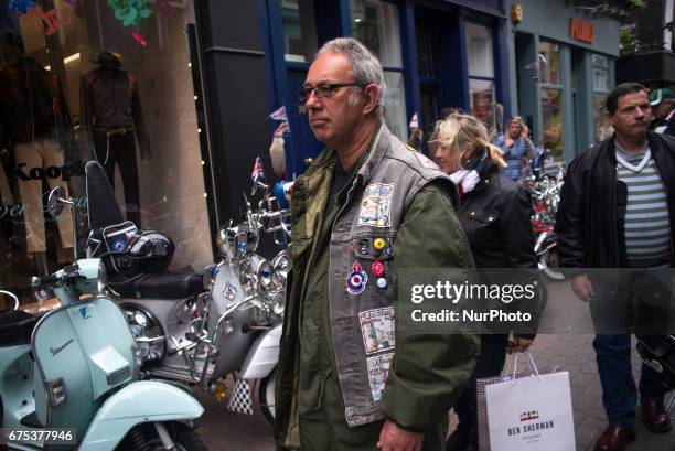 The Mods are pictured while gather with their scooters at Carnaby Street, London on April 30, 2017. Tens of Italian scooters appeared at the world...