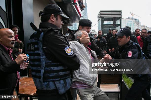 Turkish riot police arrest a protester seeking to defy a ban and march to Istanbul's Taksim square to celebrate May Day in Istanbul on May 1, 2017....