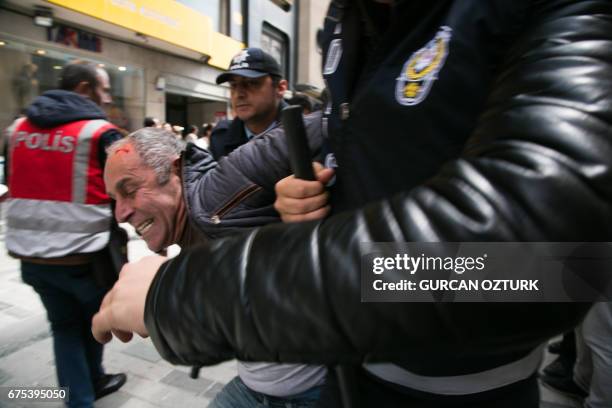 Turkish riot police arrest a protester seeking to defy a ban and march to Istanbul's Taksim square to celebrate May Day in Istanbul on May 1, 2017....