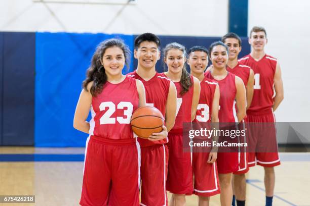 mixed gender high school basketball team posing - teenage girl basketball stock pictures, royalty-free photos & images