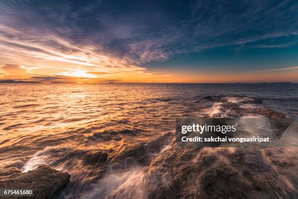 view of rocks on the beach with the sky - day and night image series stock pictures, royalty-free photos & images