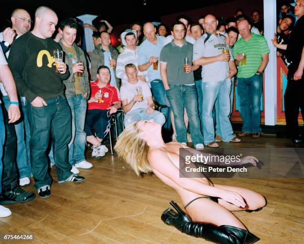 Blonde woman strips in a room full of men at Eden lap dancing club in Blackpool. April 2007.
