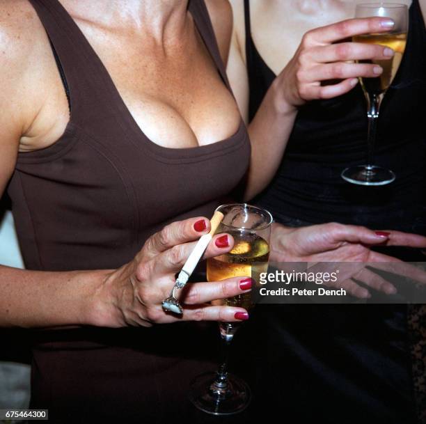 Two women drink champagne at a health resort launch party in central London. April 1998.