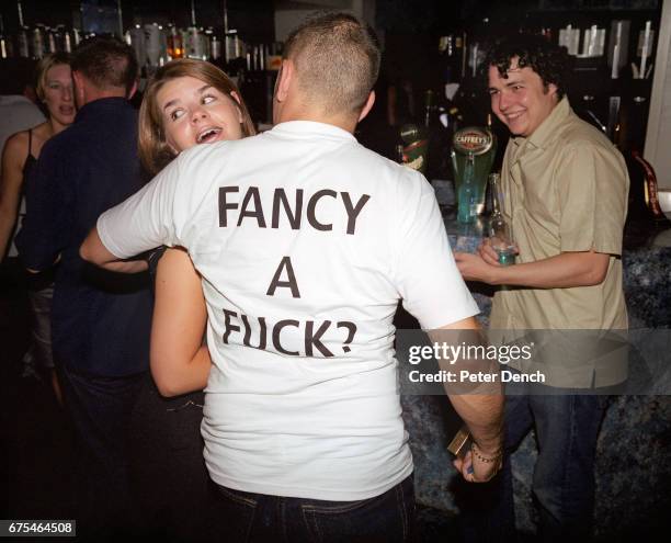 Man wearing an explicit T-shirt attempts to chat to a young woman in a Newquay nightclub. July 2001.