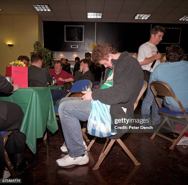 Visitor to a CAMRA beer festival in north London takes a nap in his seat. March 2001.