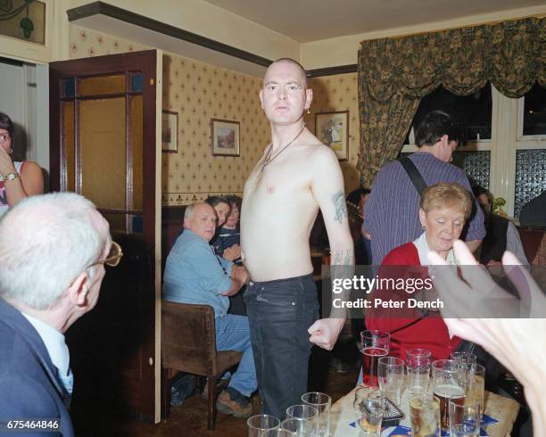 Bare-chested skinhead postures in a pub in the Lancashire town of Bacup. April 2001.
