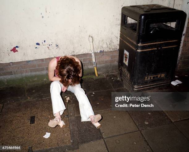 Young woman sits on the pavement of Union Street on a night out in Plymouth. November 2001.