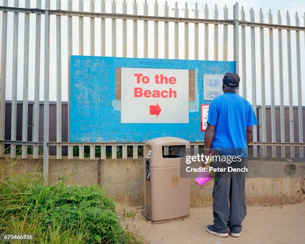 Man checks the beach opening and closing times at Butlin's Holiday Camp.