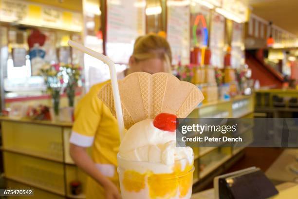 Knickerbocker glory is served in an ice cream parlour and cafe on Scarborough sea front. The elaborate ice cream sundae is served in a large tall...