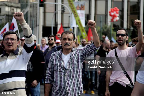 Protesters raise their fists and sing the anthem of the Socialist International in central Athens during the May Day celebrations on Monday, May 1st...