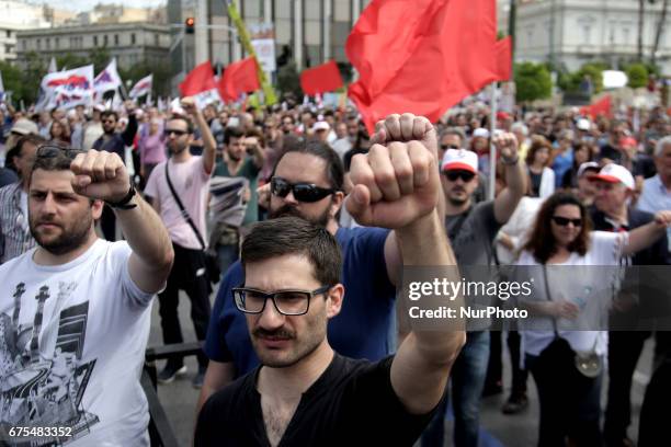 Protesters raise their fists and sing the anthem of the Socialist International in central Athens during the May Day celebrations on Monday, May 1st...