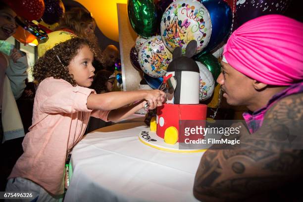 Moroccan Cannon cuts his birthday cake as dad Nick Cannon looks on at Disneyland on April 30, 2017 in Anaheim, California.
