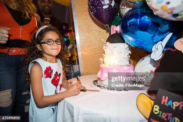 Monroe Cannon poses next to her birthday cake at Disneyland on April 30, 2017 in Anaheim, California.