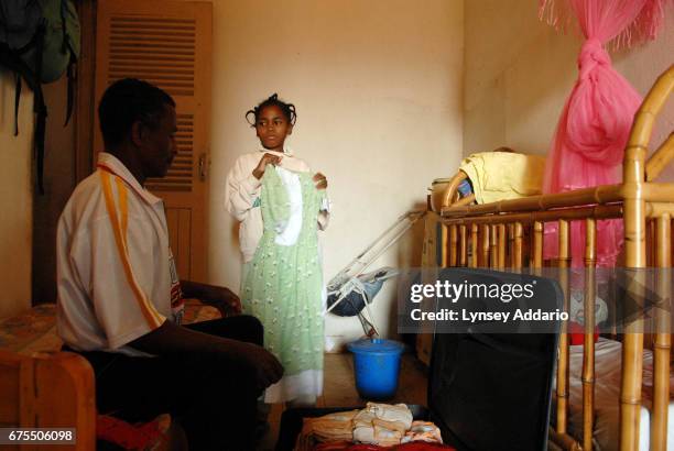 Kenia Moravelo holds up a new dress to her father, Antoine Moravelo, at the shelter where she has been staying since released from her most recent...