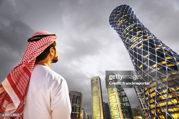 hombre mirando el skyline de doha en qatar - qatar fotografías e imágenes de stock