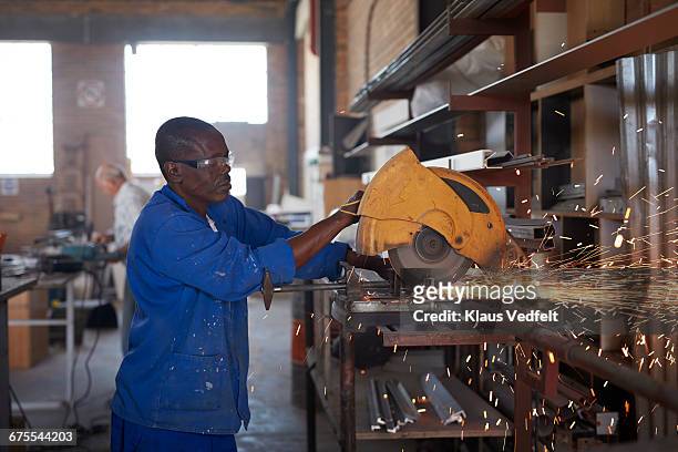 man cutting steel pipe at factory - tobacco workers stockfoto's en -beelden
