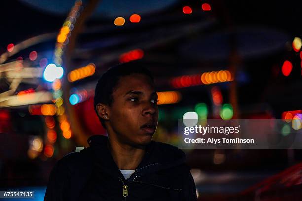 portrait of teenage boy at fairground at night - unfilteredtrend stock pictures, royalty-free photos & images