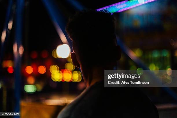 back of teenage boy at fairground at night - unfilteredtrend stock pictures, royalty-free photos & images