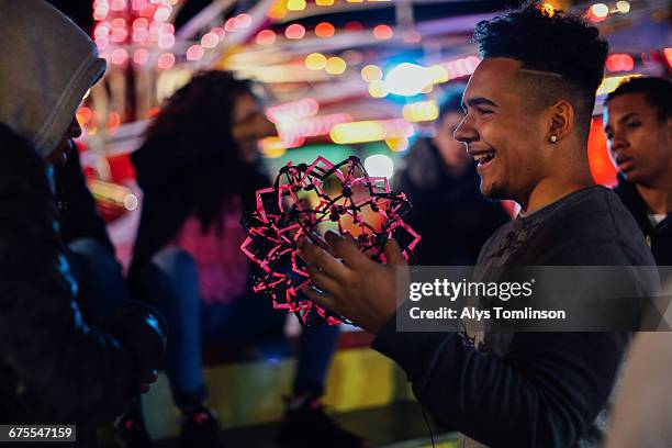teenage boy playing with toy at fairground - unfilteredtrend stock pictures, royalty-free photos & images