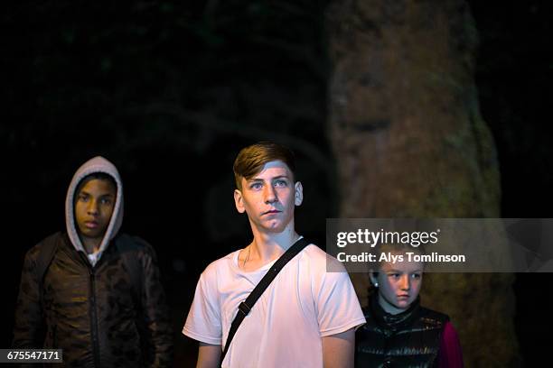 three teenagers in a park at night - unfilteredtrend stock pictures, royalty-free photos & images