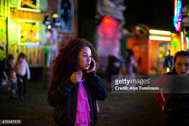 teenage girl on the phone at fairground at night - tendenciasemfiltro imagens e fotografias de stock