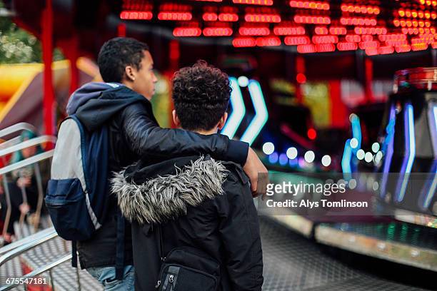 teenage boy at fair with arm around his friend - tendenciasemfiltro imagens e fotografias de stock