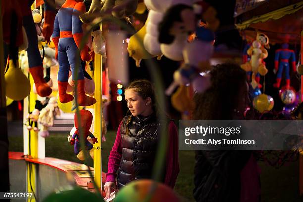 teenage girl at a fairground stall at night - unfilteredtrend stock pictures, royalty-free photos & images