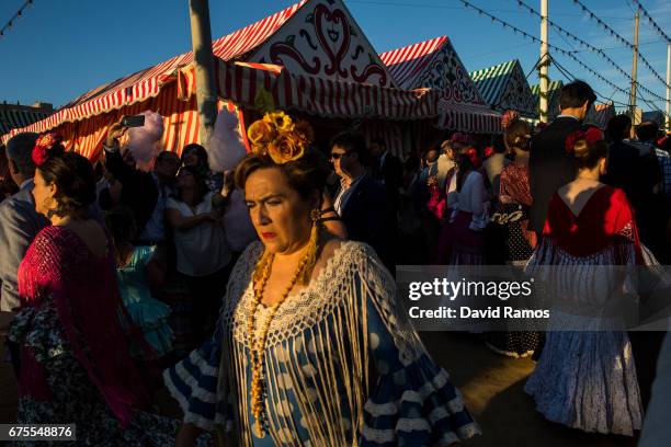 Women wearing traditional Sevillana dresses enjoy the atmosphere at the Feria de Abril on May 1, 2017 in Seville, Spain. The Feria de Abril, which...