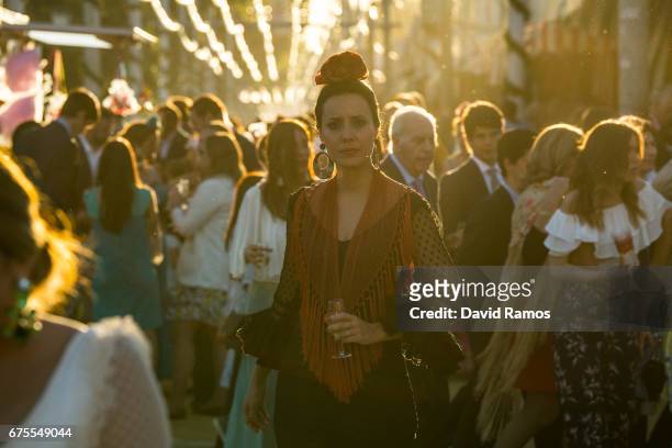 Woman wearing a traditional Sevillana dress enjoy the atmosphere at the Feria de Abril on May 1, 2017 in Seville, Spain. The Feria de Abril, which...