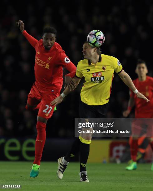 Divock Origi of Liverpool heads the ballunder pressure from Sebastian Prodl of Watford during the Premier League match between Watford and Liverpool...