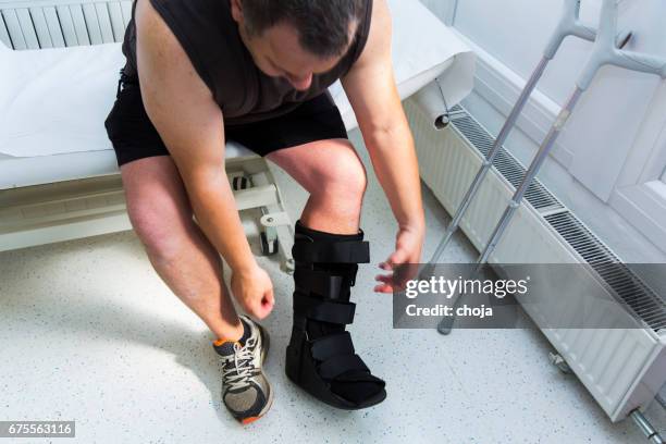 gespierde atleet met walking schoen voor achillespees behandeling - ankle boot stockfoto's en -beelden