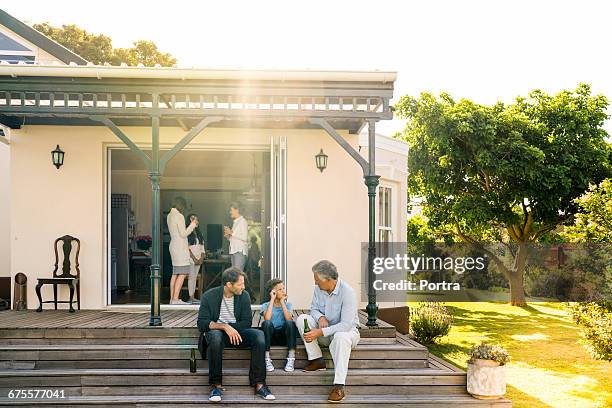 family relaxing at home on sunny day - family porch foto e immagini stock