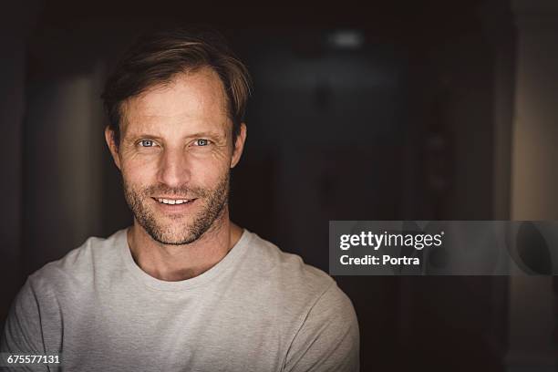 portrait of confident smiling man standing at home - handsome bildbanksfoton och bilder